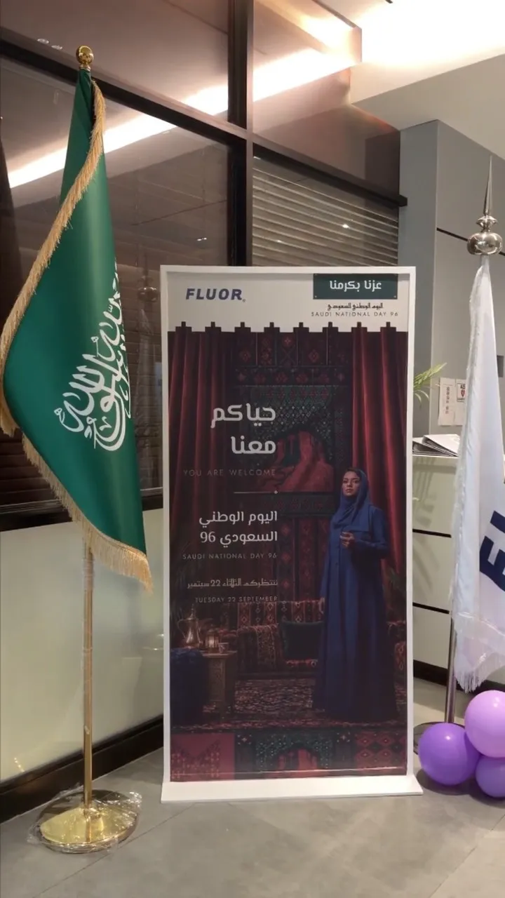 A Saudi flag, the occasion banner and balloons in the building lobby