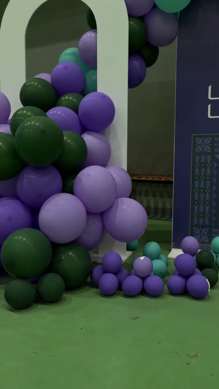 A green and purple balloon arch at the entrance